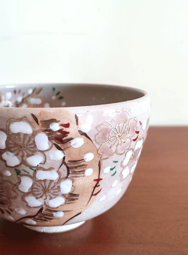 Embrace the Elegance of Spring with the Handmade 'Sakura Fubuki' Matcha Bowl Experience the art of tea with the 'Sakura Fubuki' Matcha Bowl, a masterpiece meticulously hand-painted by the esteemed Japanese craftsman, 八木海峰 Yagi Kaihou. Born in the heart of Kyoto, Yagi Kaihou brings the beauty of fully bloomed Sakura to life, with each petal delicately outlined in gold and painted in soft hues of pink and white. A Tribute to Kiyomizu Ware Tradition This exquisite bowl is a proud representation of Kiyomizu ware, a prestigious form of Kyō ware that hails from the historic Gojōzaka district, near the iconic Kiyomizu Temple in Kyoto. With a rich heritage dating back to the 16th century, Kiyomizu ware is celebrated for its intricate craftsmanship and timeless elegance. About the Artist: Yagi Kaihou Yagi Kaihou's journey in ceramics is marked by notable achievements, including a live demonstration of his painting skills in the presence of Her Majesty the Empress in 1968. His talent further graced international stages with a Kyo-ware and Kiyomizu-ware exhibition in Paris in 1993, where he showcased his painting prowess. Recognized for his contributions to traditional Japanese ceramics, he was certified as a traditional craftsman in 2003, a testament to his mastery and dedication to the art. Signature of Authenticity Each 'Sakura Fubuki' Matcha Bowl carries the unique stamp of Yagi Kaihou at its base, serving as a seal of authenticity and a tribute to the artisan's legacy. This bowl is not just a vessel for tea; it is a piece of Japanese heritage, inviting you to partake in a centuries-old tradition of elegance and craftsmanship. Available at j-okini Malta