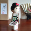 Handcrafted Japanese Kokeshi doll 'Sakura Komachi' by artist Yamagishi Masayoshi, featuring a kanzashi hair bun and a kimono with hand-painted pink and blue cherry blossoms. Available at j-okini.com in Malta
