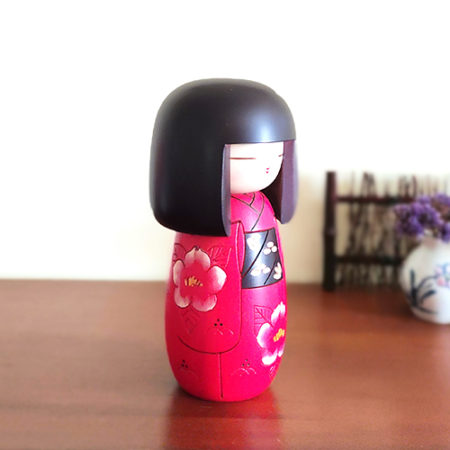 Japanese Benitsubaki Kokeshi doll with intricate camellia flower designs in red and white, symbolizing elegance and nobility in Japanese culture.. Available at j-okini.com in Malta Europe