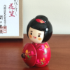 Kokeshi doll named Hanagasa holding an umbrella wearing red kimono. Made in Japan. Buy it online at j-okini.com in Malta