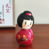 Kokeshi doll named Hanagasa holding an umbrella wearing red kimono. Made in Japan. Buy it online at j-okini.com in Malta