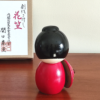 Kokeshi doll named Hanagasa holding an umbrella wearing red kimono. Made in Japan. Buy it online at j-okini.com in Malta