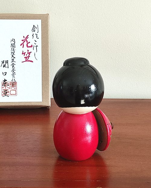 Kokeshi doll named Hanagasa holding an umbrella wearing red kimono. Made in Japan. Buy it online at j-okini.com in Malta