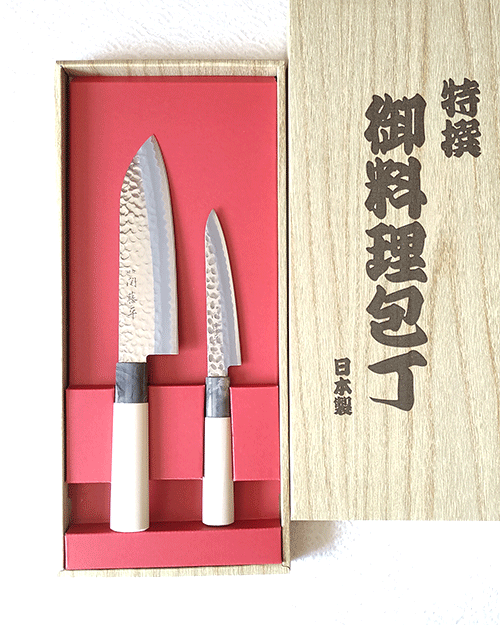 Yaxell, a revered name in the world of fine Japanese cutlery since 1932, presents a gift set that embodies the spirit of Gifu and Seki's legendary knife-making tradition. These regions are celebrated for producing some of the most sought-after kitchen knives, known for their auspicious qualities and unparalleled craftsmanship. The signature 関藤平 mark on every knife is a testament to its authenticity and heritage, ensuring you own a piece of Japanese history. Blade It features a beautiful hammered design and provides comfortable cutting. Handle Both knives feature handles made from magnolia wood, renowned for its beauty and durability. This gift set includes: 1. 三得包丁 Santoku Bocho Overall length 295mm Blade length 165mm Weight: 79g The Santoku Bocho is the epitome of versatility, designed to handle all types of food with ease. Its balanced weight and size make it the perfect tool for any culinary challenge, embodying the harmony of traditional Japanese craftsmanship and modern needs. 2.ペティ petty Overall length 235mm Blade length 120mm Weight: 44g The Petty knife, a compact counterpart of the ‘Gyutou’, offers exceptional maneuverability and precision. Ideal for intricate tasks, its small size and sharp edge allow for detailed work, making it an indispensable tool in any kitchen.. Available at j-okini.com in Malta