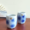 Experience the elegance of Arita ware with this exquisite Naga Yunomi (tall teacup). Aritaware , with over four centuries of rich history and tradition, is a testament to the masterful craftsmanship passed down through generations. Each piece embodies the skill and precision that Arita artisans are renowned for. This teacup features a striking blue polka dot pattern, delicately faded to create a soft, calming aesthetic. Its unique design includes three small legs at the base, adding a distinct touch of character and balance to the cup. Whether for daily use or as a display piece, this Arita ware Yunomi perfectly blends tradition and artistry. Available at j-okini.com in Malta