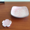 This charming set features a light pink Sakura plate paired with a matching Sakura-shaped chopstick rest. The square plate, adorned with delicate cherry blossom (Sakura) patterns, has a slight depth, making it perfect for serving soy sauce or small side dishes. Both pieces are crafted in the Mino ware (Mino-yaki) tradition, a celebrated Japanese pottery style known for its beautiful and functional designs. Available at j-okini.com in Malta