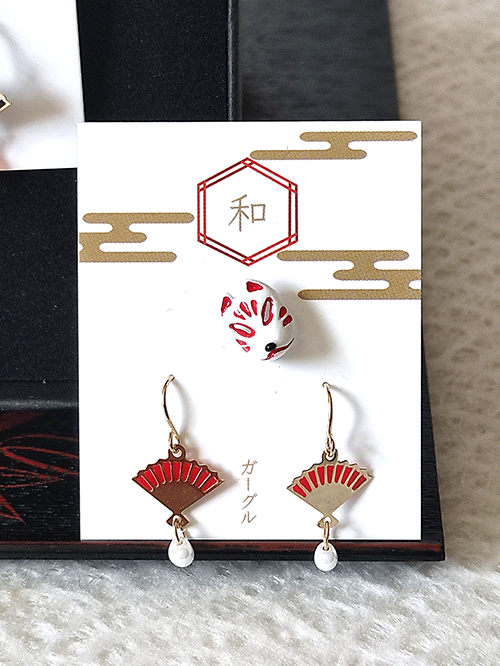 A set of Kitsune mask earrings and a pair of fan earrings. Available at j-okini.com in Malta