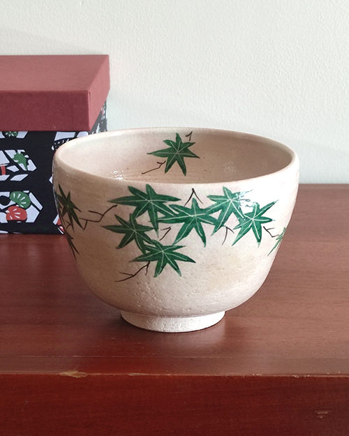 Kiyomizu-ware handmade Matcha bowl with green maple leaves painted on a warm beige base, inspired by Japan's early summer foliage. Buy it at j-okini in Malta.