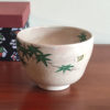 Kiyomizu-ware Matcha bowl with green maple leaves design on a warm beige background, inspired by Japanese summer landscapes. Available at j-okini.com in Malta