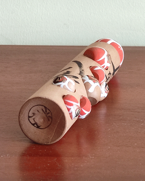 Vintage wooden Daruma doll with seven smaller Daruma figures, inscribed with the proverb 'Nanakorobi Yaoki' for resilience, stamped from Kawayu Onsen area, 17.5 cm tall with craftsman's mark. Available at j-okini.com in Malta