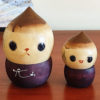 A pair of vintage wooden dolls shaped like acorns, with removable tops representing the acorn heads. The dolls show signs of age with slight scratches. One is larger, measuring approximately H10 x W6.5cm, and the smaller one is H6.5 x W4cm. These unique pieces come from a personal collection in Japan, tied to Mount Daisen in Tottori Prefecture.. Available at j-okini.com in Malta