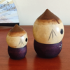 A pair of vintage wooden dolls shaped like acorns, with removable tops representing the acorn heads. The dolls show signs of age with slight scratches. One is larger, measuring approximately H10 x W6.5cm, and the smaller one is H6.5 x W4cm. These unique pieces come from a personal collection in Japan, tied to Mount Daisen in Tottori Prefecture.. Available at j-okini.com in Malta