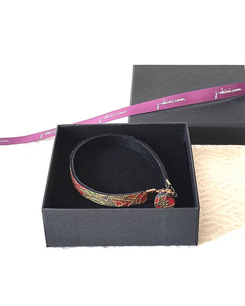 Floral Mist handmade leather bracelet with a light grey base and pink, purple, and green floral pattern, traced in gold, with a matching charm and magnetic clasp