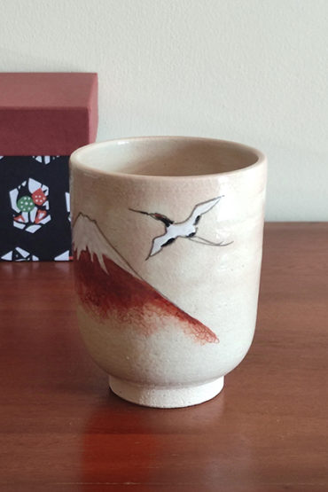 Kiyomizu-ware Yunomi tea cup featuring Red Fuji and crane design on a warm beige base with subtle orange-pink flecks. Available at j-okini.com in Malta