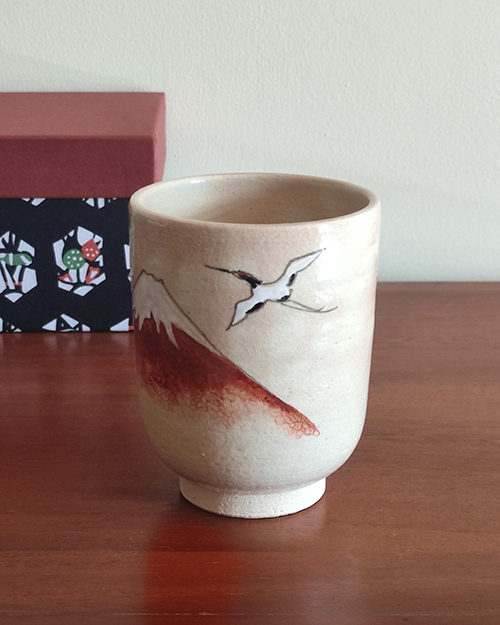 Kiyomizu-ware Yunomi tea cup featuring Red Fuji and crane design on a warm beige base with subtle orange-pink flecks. Available at j-okini.com in Malta