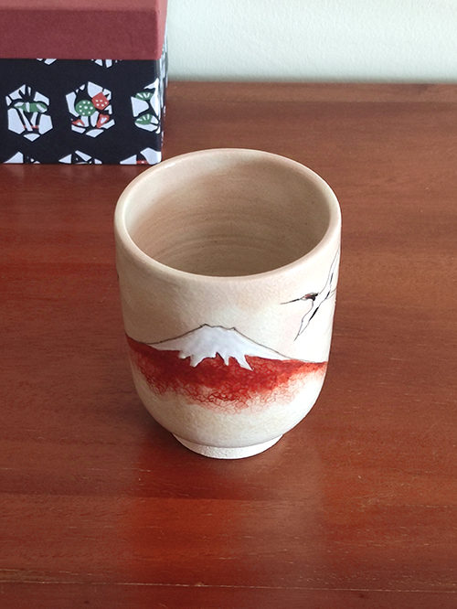 Kiyomizu-ware Yunomi tea cup featuring Red Fuji and crane design on a warm beige base with subtle orange-pink flecks. Available at j-okini.com in Malta