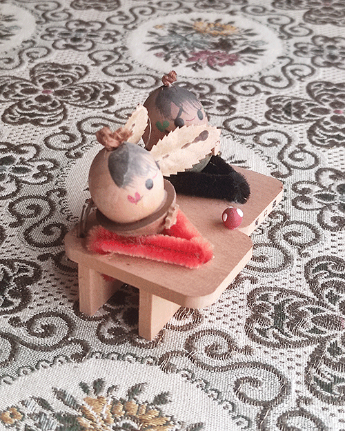 Vintage Wooden Dolls from the Showa Era. A pair of donguri dolls seated on wooden geta sandals, featuring hand-painted details and a mushroom accent.. Available at j-okini.com in Malta