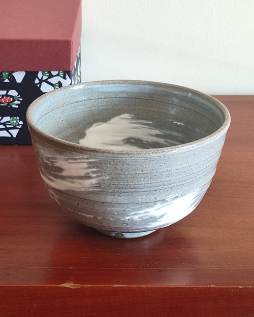 Kiyomizu-ware handmade matcha bowl with Hakeme brushstroke technique on a gray base, with white strokes and hints of light blue by artist Hiroki Shirai. j-okini.com in Malta