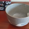 Kiyomizu-ware handmade matcha bowl with Hakeme brushstroke technique on a gray base, with white strokes and hints of light blue by artist Hiroki Shirai. j-okini.com in Malta