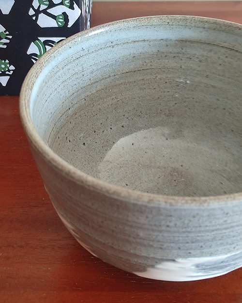 Kiyomizu-ware handmade matcha bowl with Hakeme brushstroke technique on a gray base, with white strokes and hints of light blue by artist Hiroki Shirai. j-okini.com in Malta