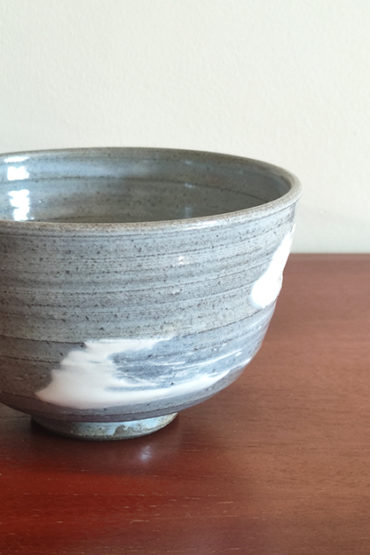 Kiyomizu-ware handmade matcha bowl with Hakeme brushstroke technique on a gray base, with white strokes and hints of light blue by artist Hiroki Shirai. j-okini.com in Malta