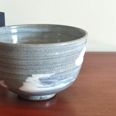 Kiyomizu-ware handmade matcha bowl with Hakeme brushstroke technique on a gray base, with white strokes and hints of light blue by artist Hiroki Shirai. j-okini.com in Malta