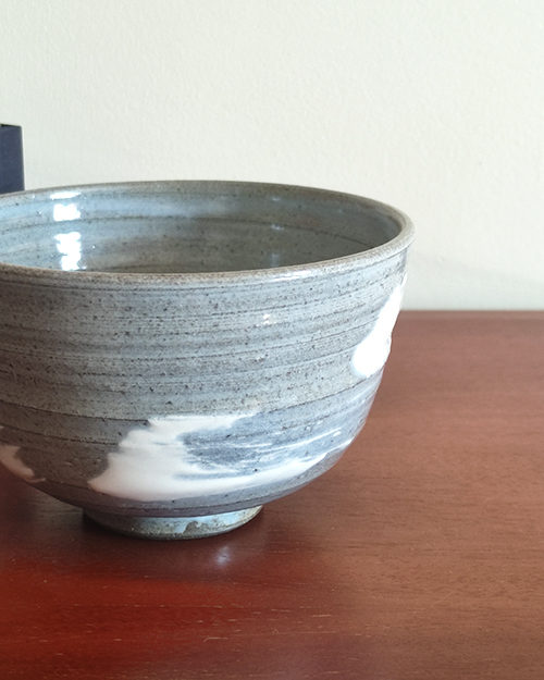 Kiyomizu-ware handmade matcha bowl with Hakeme brushstroke technique on a gray base, with white strokes and hints of light blue by artist Hiroki Shirai. j-okini.com in Malta