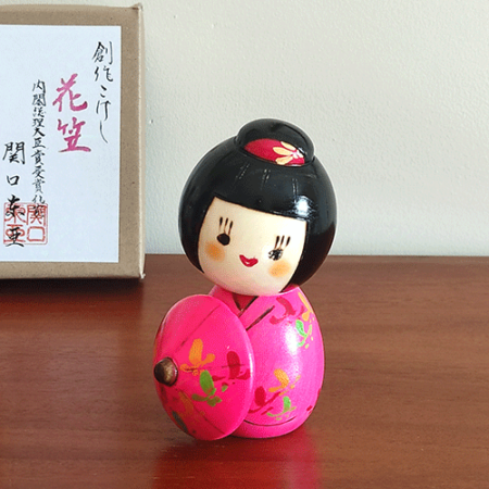 Kokeshi doll named Hanagasa by Sekiguchi Toua, wearing vivid pink kimono and holding an umbrella. j-okini.com in Malta