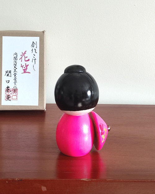 Kokeshi doll named Hanagasa by Sekiguchi Toua, wearing vivid pink kimono and holding an umbrella. j-okini.com in Malta