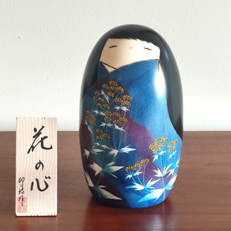 Handcrafted Kokeshi doll named Hana no Kokoro,by Usaburo adorned with floral patterns, symbolizing a heart of flowers and expressing grace and beauty in Japanese artistry.. Buy it online at j-okini.com in Malta