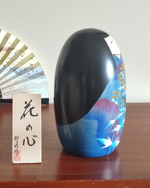 Handcrafted Kokeshi doll named Hana no Kokoro,by Usaburo adorned with floral patterns, symbolizing a heart of flowers and expressing grace and beauty in Japanese artistry.. Buy it online at j-okini.com in Malta