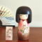 Kokeshi doll named Jokamachi featuring a beautiful depiction of a castle and delicate cherry blossoms on a soft pink kimono, symbolizing the elegance and history of Japanese heritage.. Buy it online at j-okini.com in Malta