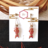 Handmade earrings in a shape of Koinobori - carp streamer. Three-dimensional design, each pair is painted in three vibrant, stained-glass-like colors red pink and orange. Available at j-okini.com in Malta