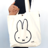 Miffy's slim canvas tote bag in white with a large Miffy illustration in black. button closure tote bag. Spacious tote bag. Japanese tote bag. Availabe at j-okini.com in Malta