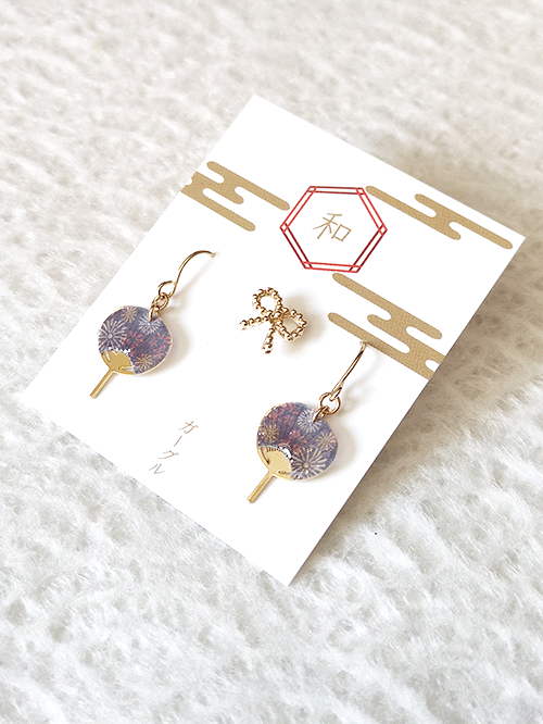 Buy Japanese earring set including two mini uchiwa fan featuring a vibrant fireworks (hanabi) pattern earrings with hooks , paired with a cute ribbon stud earring. Uchiwa fan has the desi Made in Japan! Available at j-okini.com in Malta