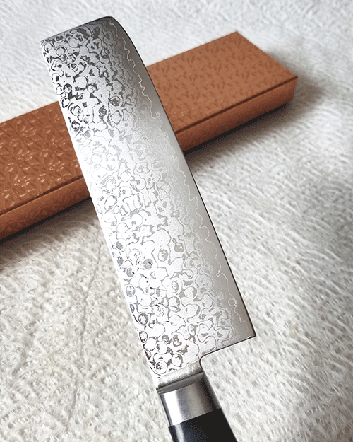 Japanese Nakiri kitchen knife with VG10 core, 16-layer Damascus wave pattern, and a rectangular shape, ideal for precise vegetable slicing and chopping.. Buy it from j-oini.com in Malta