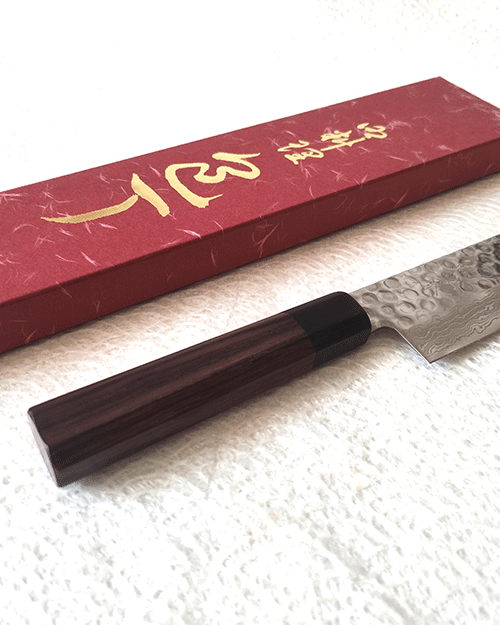 Handcrafted Japanese Nakiri kitchen knife with a hammered and wave-patterned AUS10 stainless steel blade, octagonal rosewood handle, and traditional craftsmanship. Available at j-okini in Malta