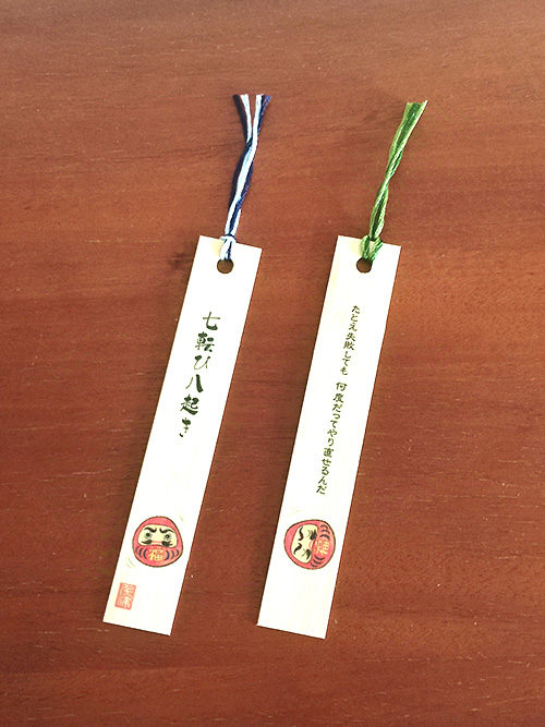 Bamboo bookmark with Daruma doll and Japanese proverb Nanakorobi Yaoki, symbolizing resilience with motivational text on the back. j-okini.com in Malta