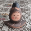 Vintage Wooden Dolls from the Showa Era shaped like an aubergine with a sweet face resting on a wooden leaf