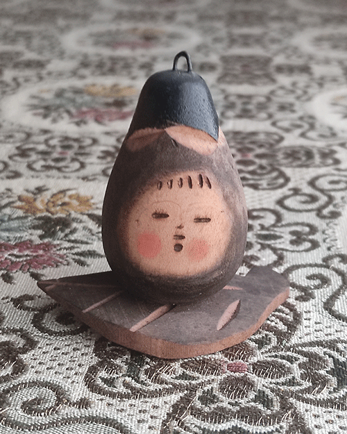 Vintage Wooden Dolls from the Showa Era shaped like an aubergine with a sweet face resting on a wooden leaf