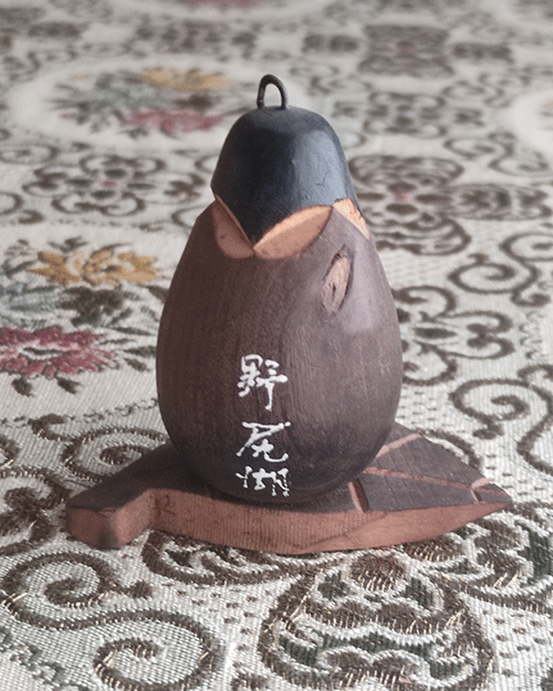 Vintage Wooden Dolls from the Showa Era shaped like an aubergine with a sweet face resting on a wooden leaf