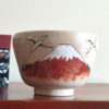 Handcrafted Kiyomizu-ware Matcha bowl featuring Red Fuji and crane design on a warm beige background with soft pink and orange speckles.. Gift idea from j-okini.com in Malta