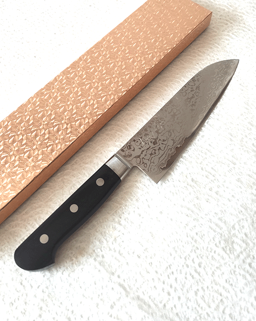 Japanese Santoku kitchen knife with a VG10 Damascus blade featuring a unique wave pattern and an elegant, simple handle. buy it at j-okini.com in Malta