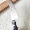 Japanese Santoku kitchen knife with a VG10 Damascus blade featuring a unique wave pattern and an elegant, simple handle. buy it at j-okini.com in Malta