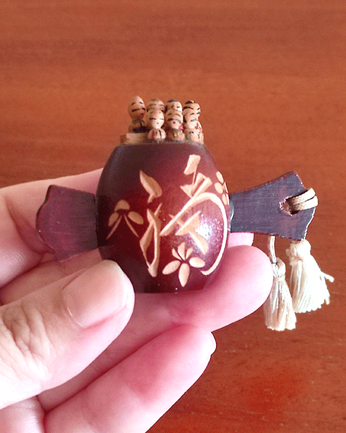 Vintage miniature Shichifukujin wooden doll on Tsutsumi from the Showa era. Features seven hand-painted lucky gods on a carved Tsutsumi with a 福 'luck' kanji and floral design. Available at j-okini.com in malta