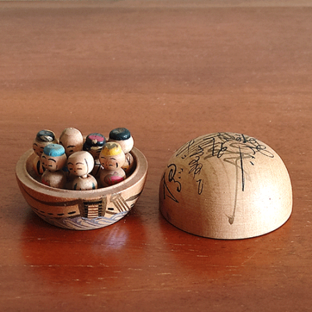 Vintage miniature wooden Shichifukujin doll set on a hand-painted boat with removable calligraphy lid, showing the Seven Lucky Gods with turnable heads. Antique Japan.