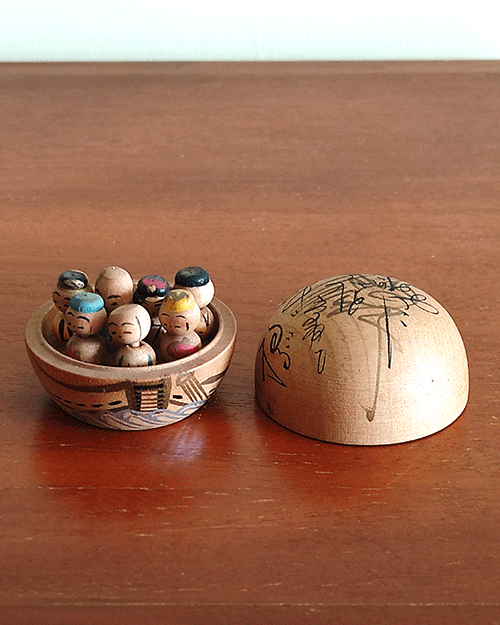 Vintage miniature wooden Shichifukujin doll set on a hand-painted boat with removable calligraphy lid, showing the Seven Lucky Gods with turnable heads. Antique Japan.