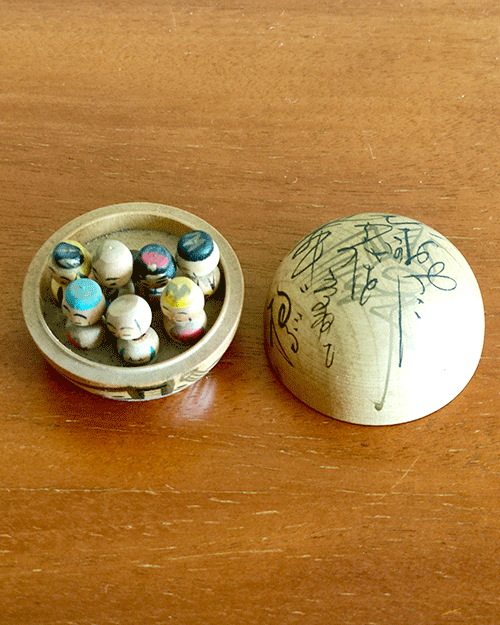 Vintage miniature wooden Shichifukujin doll set on a hand-painted boat with removable calligraphy lid, showing the Seven Lucky Gods with turnable heads. Antique Japan.