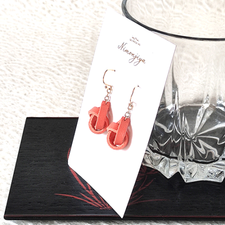 Handmade leather earrings featuring a twist-like design, dyed in traditional Japanese Shuiro (vermilion) using the Kyo-Yuzen dyeing technique, inspired by Kyoto's rich heritage.