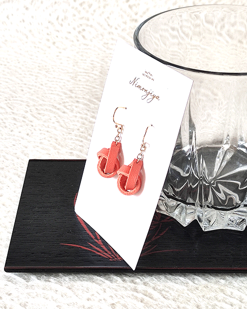 Handmade leather earrings featuring a twist-like design, dyed in traditional Japanese Shuiro (vermilion) using the Kyo-Yuzen dyeing technique, inspired by Kyoto's rich heritage.